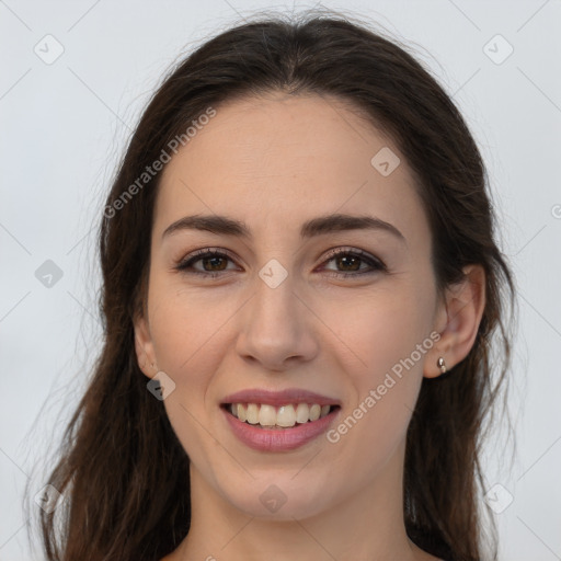 Joyful white young-adult female with long  brown hair and brown eyes