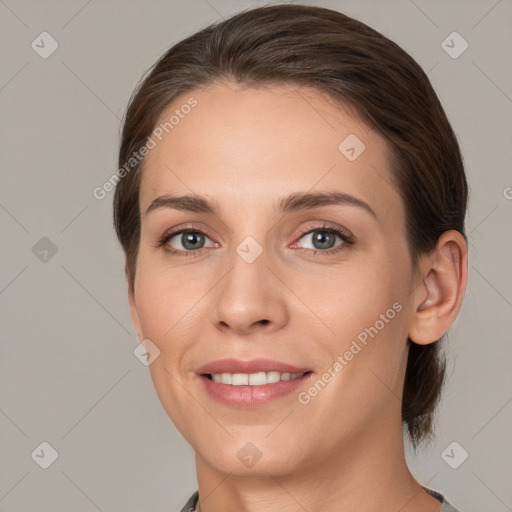 Joyful white young-adult female with medium  brown hair and grey eyes