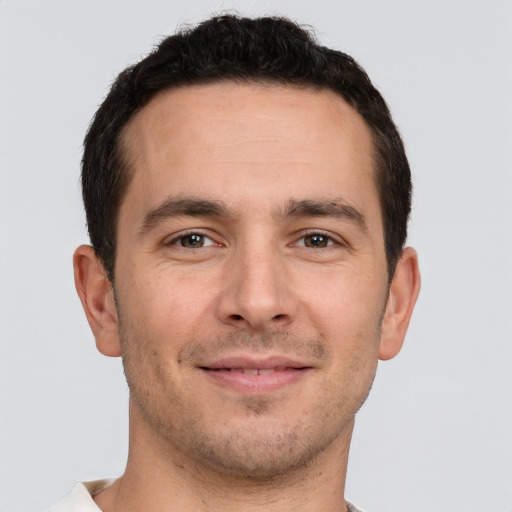 Joyful white young-adult male with short  brown hair and brown eyes