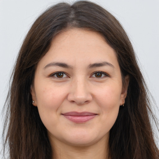 Joyful white young-adult female with long  brown hair and brown eyes