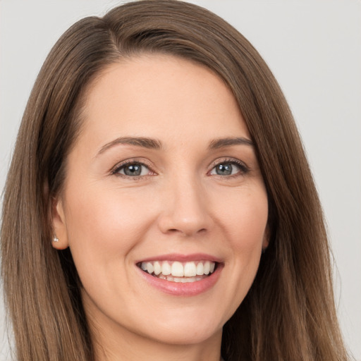 Joyful white young-adult female with long  brown hair and brown eyes