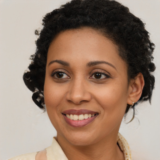 Joyful black young-adult female with long  brown hair and brown eyes