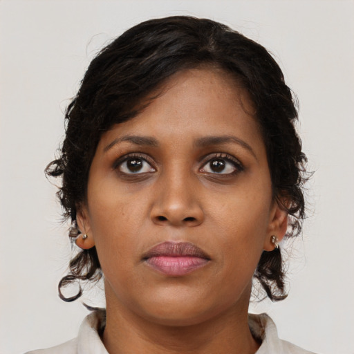 Joyful black young-adult female with medium  brown hair and brown eyes