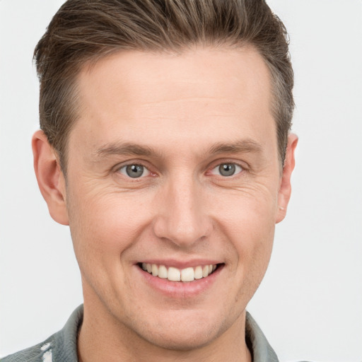 Joyful white adult male with short  brown hair and grey eyes