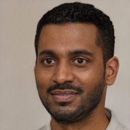 Joyful black young-adult male with short  black hair and brown eyes