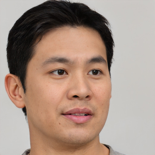 Joyful asian young-adult male with short  brown hair and brown eyes