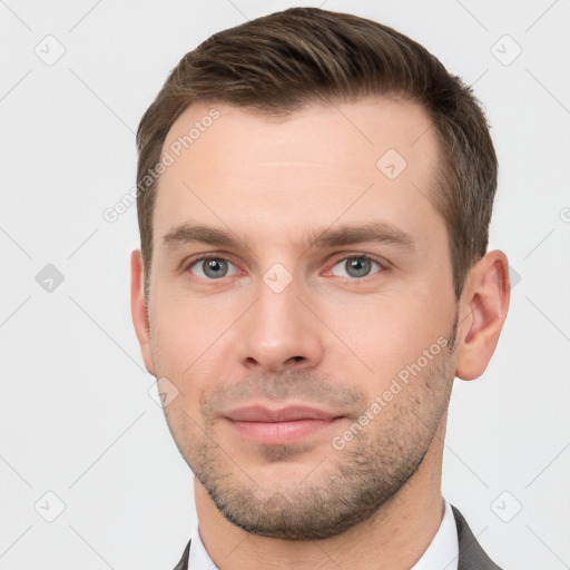 Joyful white young-adult male with short  brown hair and grey eyes