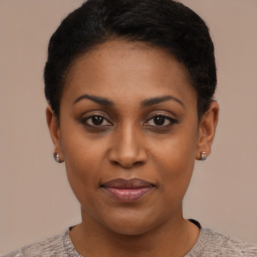 Joyful black young-adult female with short  black hair and brown eyes