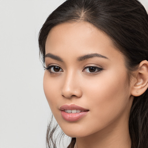 Joyful latino young-adult female with long  brown hair and brown eyes