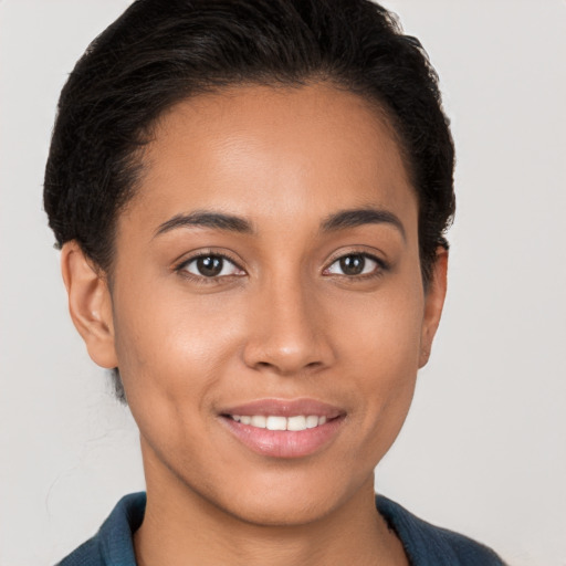 Joyful latino young-adult female with short  brown hair and brown eyes