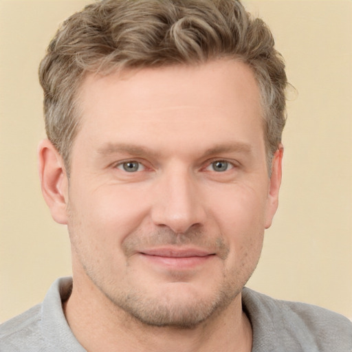 Joyful white adult male with short  brown hair and grey eyes