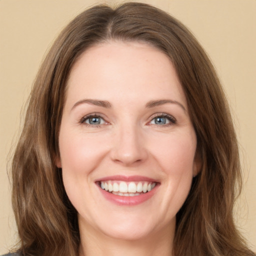 Joyful white young-adult female with long  brown hair and green eyes