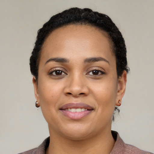 Joyful black young-adult female with short  black hair and brown eyes