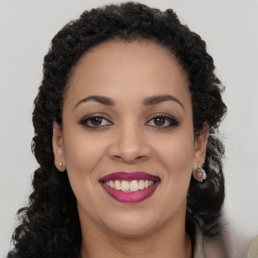 Joyful black young-adult female with long  black hair and brown eyes