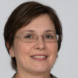 Joyful white adult female with medium  brown hair and blue eyes