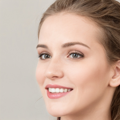 Joyful white young-adult female with long  brown hair and grey eyes