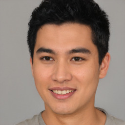 Joyful asian young-adult male with short  black hair and brown eyes