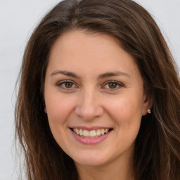 Joyful white young-adult female with long  brown hair and brown eyes