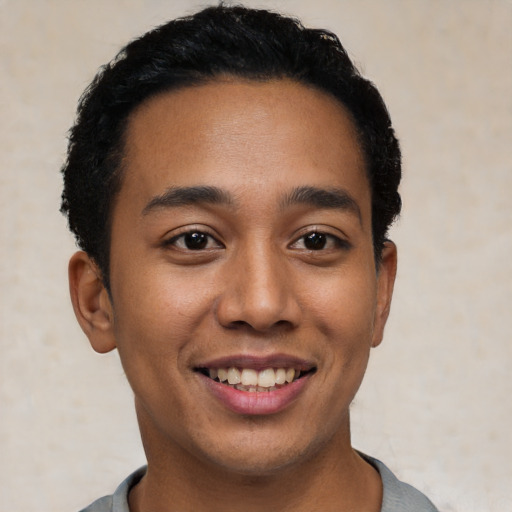 Joyful latino young-adult male with short  black hair and brown eyes