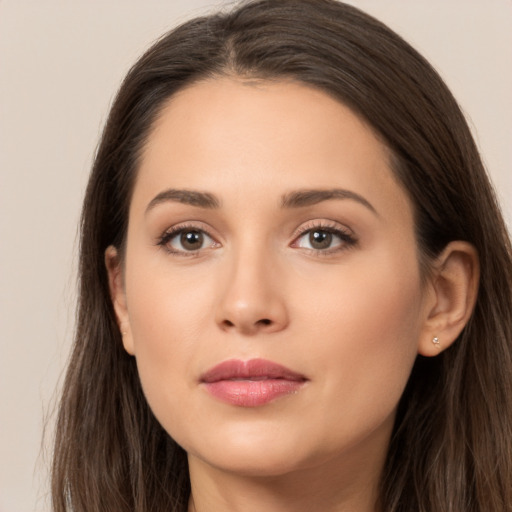 Joyful white young-adult female with long  brown hair and brown eyes