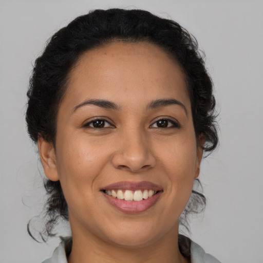 Joyful latino young-adult female with medium  brown hair and brown eyes