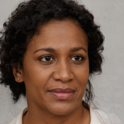 Joyful black adult female with medium  brown hair and brown eyes