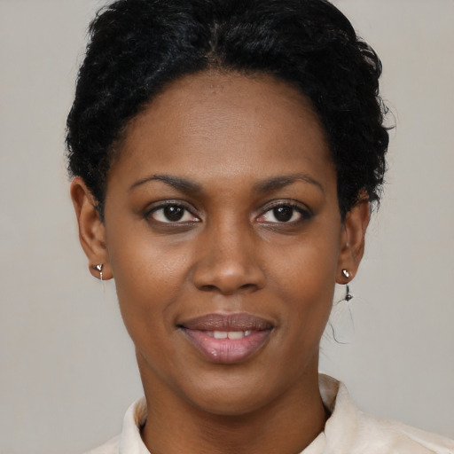 Joyful black young-adult female with short  black hair and brown eyes