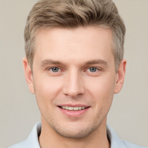 Joyful white young-adult male with short  brown hair and grey eyes