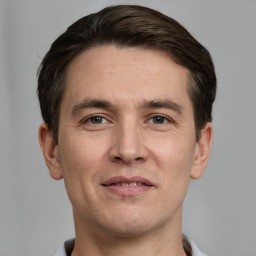 Joyful white young-adult male with short  brown hair and grey eyes