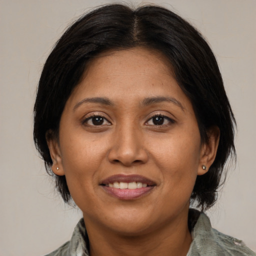 Joyful latino adult female with medium  brown hair and brown eyes