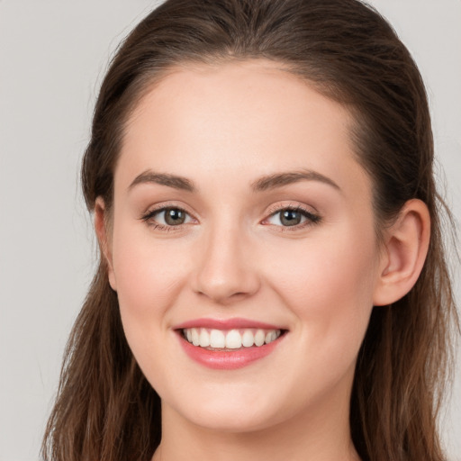 Joyful white young-adult female with long  brown hair and grey eyes