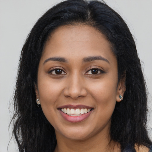 Joyful latino young-adult female with long  brown hair and brown eyes