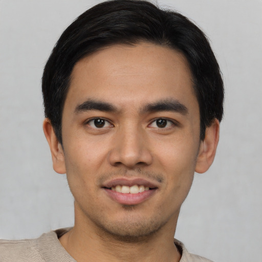 Joyful white young-adult male with short  black hair and brown eyes