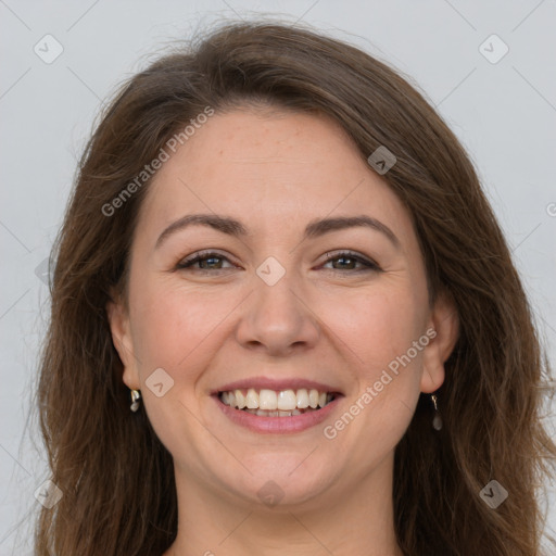 Joyful white adult female with long  brown hair and brown eyes