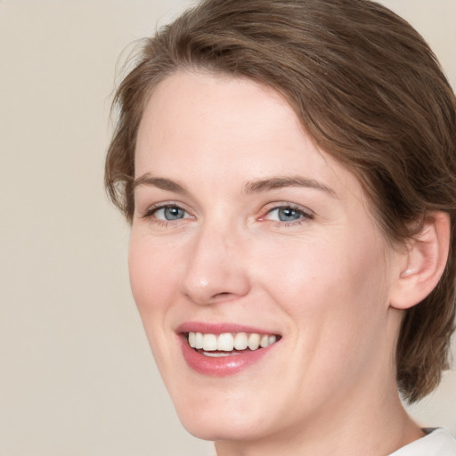 Joyful white young-adult female with medium  brown hair and blue eyes