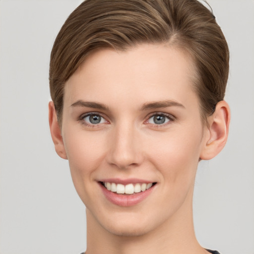 Joyful white young-adult female with short  brown hair and grey eyes