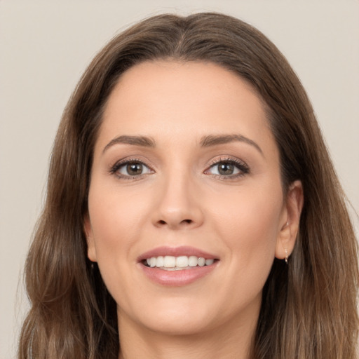 Joyful white young-adult female with long  brown hair and brown eyes