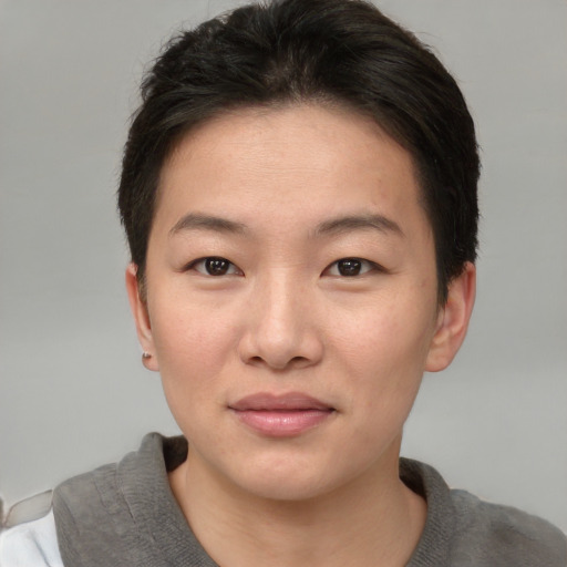 Joyful asian young-adult female with short  brown hair and brown eyes