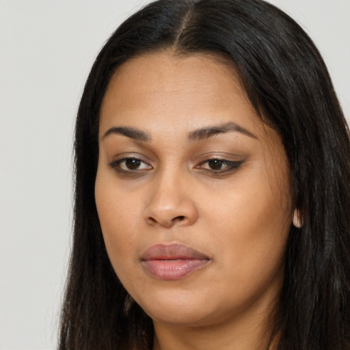 Joyful black young-adult female with long  brown hair and brown eyes