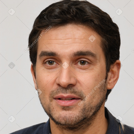 Joyful white adult male with short  black hair and brown eyes