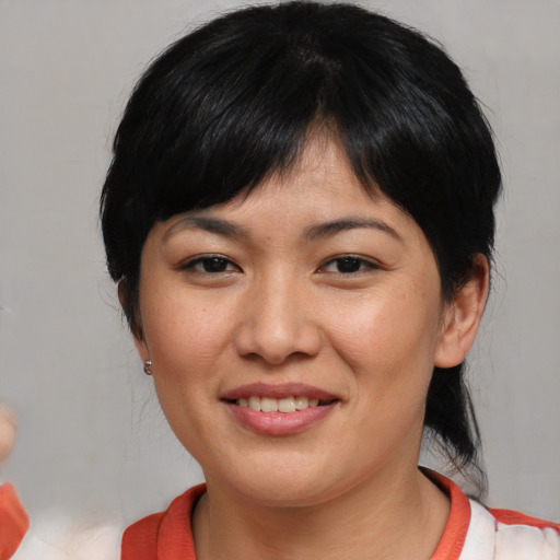 Joyful asian young-adult female with medium  black hair and brown eyes