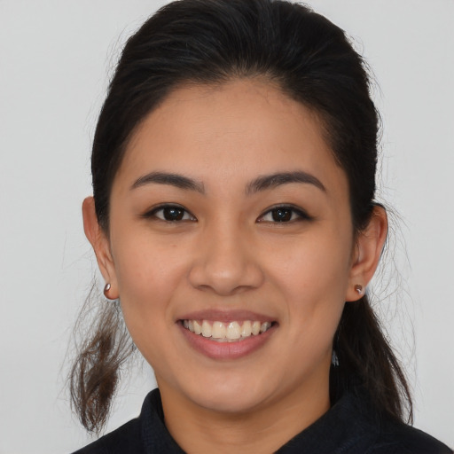 Joyful latino young-adult female with long  brown hair and brown eyes