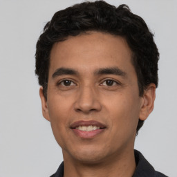 Joyful white young-adult male with short  black hair and brown eyes