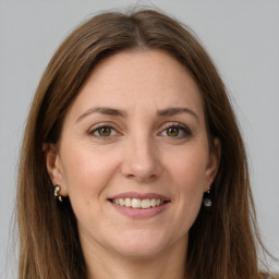 Joyful white adult female with long  brown hair and grey eyes