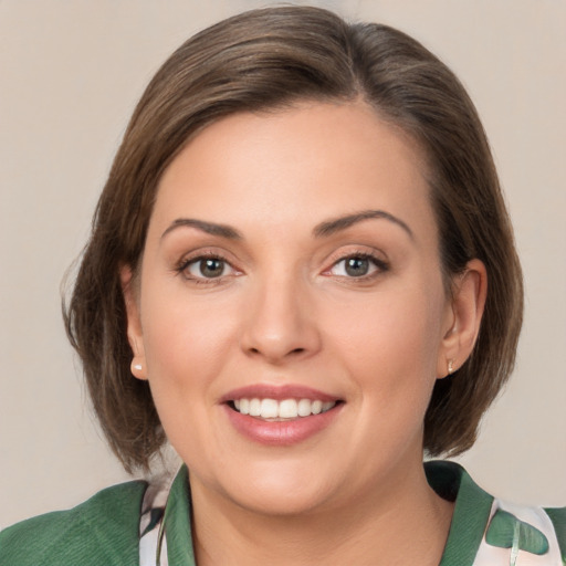 Joyful white young-adult female with medium  brown hair and green eyes