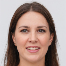 Joyful white young-adult female with long  brown hair and grey eyes