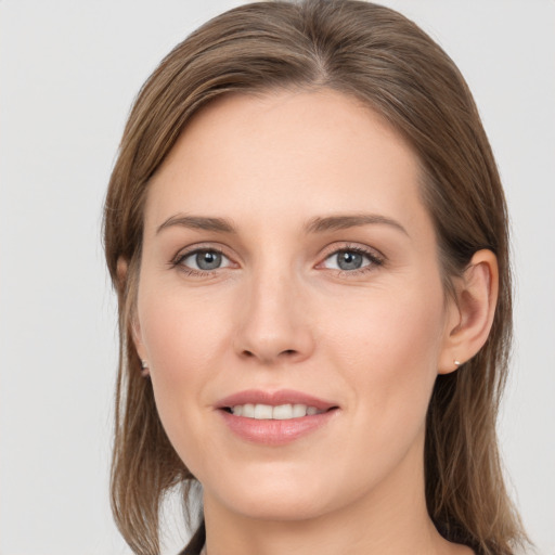 Joyful white young-adult female with long  brown hair and grey eyes