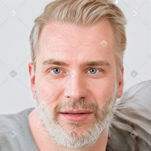 Joyful white adult male with short  brown hair and blue eyes