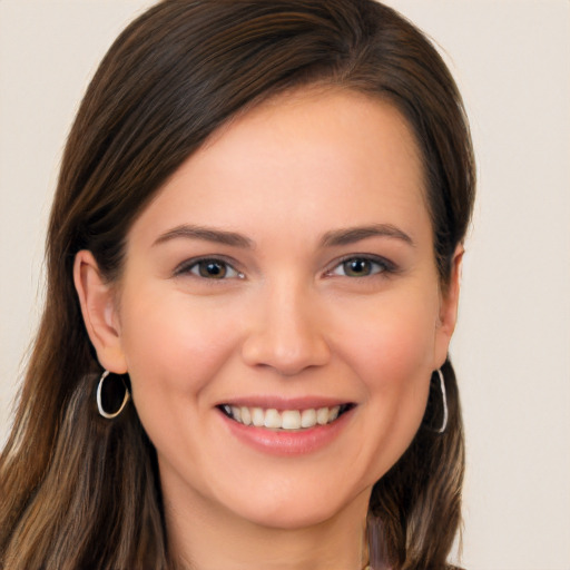 Joyful white young-adult female with long  brown hair and brown eyes