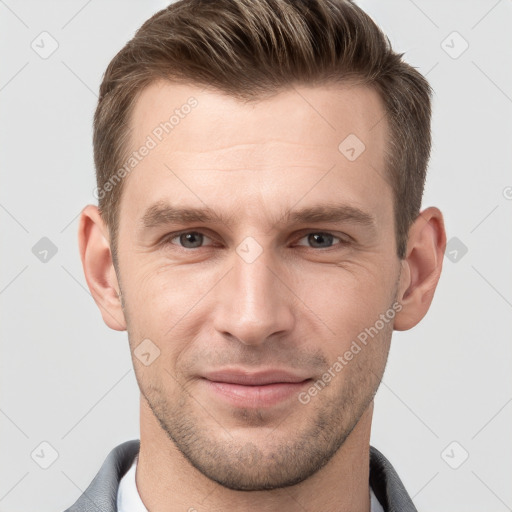 Joyful white young-adult male with short  brown hair and grey eyes